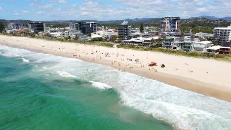 Turistas-En-La-Playa-De-Palmeras-En-La-Costa-Dorada-Durante-El-Verano---Suburbio-Costero-En-Qld,-Australia---Drone-De-Retroceso