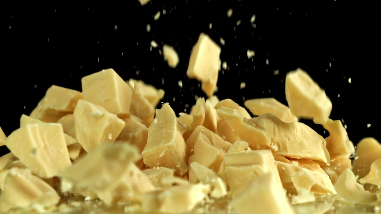 Delicious White Chocolate Pieces Falling in Slow Motion