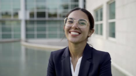 smiling businesswoman looking at camera and adjusting hair