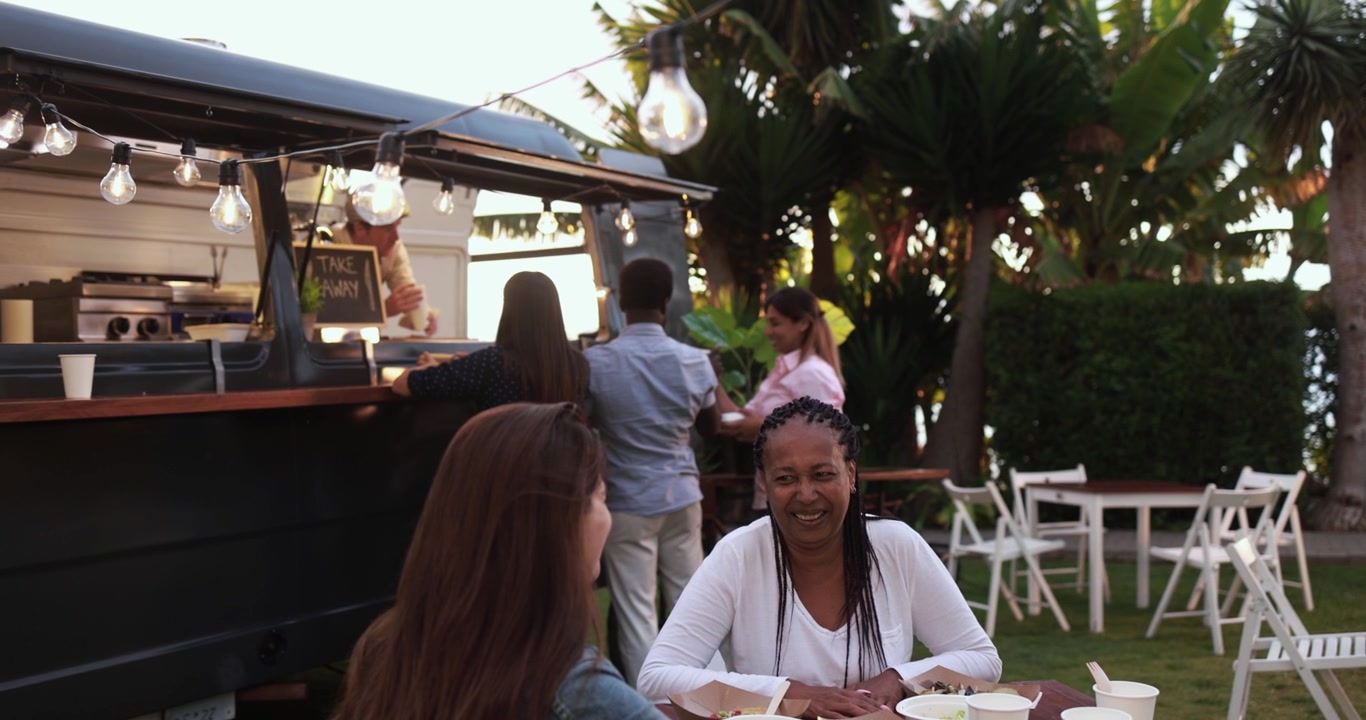 Diverse Friends Enjoying Food Truck Meal in an Outdoor Garden