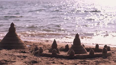 castle of sand with asian elements on shore slow motion