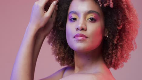 mujer biracial con cabello oscuro sobre fondo púrpura, cámara lenta