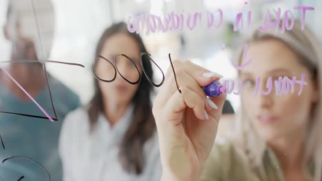 busy diverse business people taking notes on glass wall in slow motion