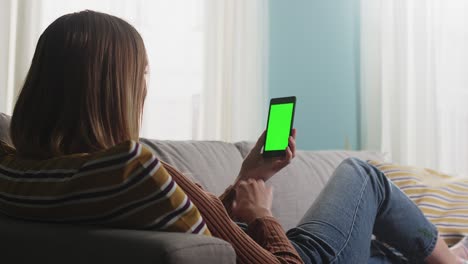 la chica está tendida en el sofá y hablando en una llamada de video.