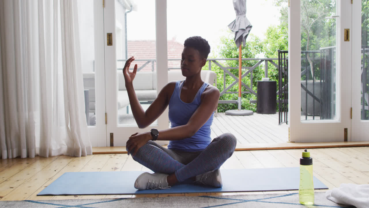 African american woman performing stretching exercise at home