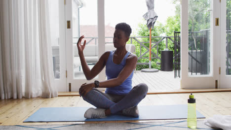 african american woman performing stretching exercise at home