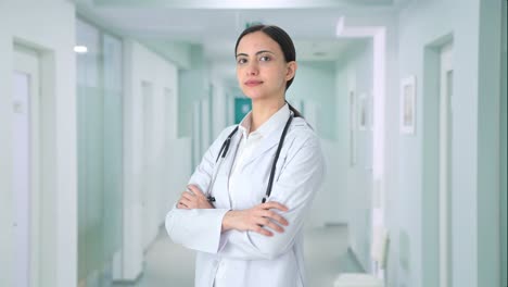 portrait of indian female doctor standing crossed hands