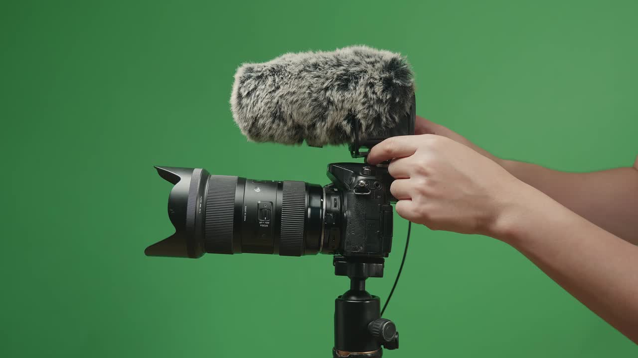 Close Up Hands Male Put Microphone On Digital Camera In Green Screen Studio