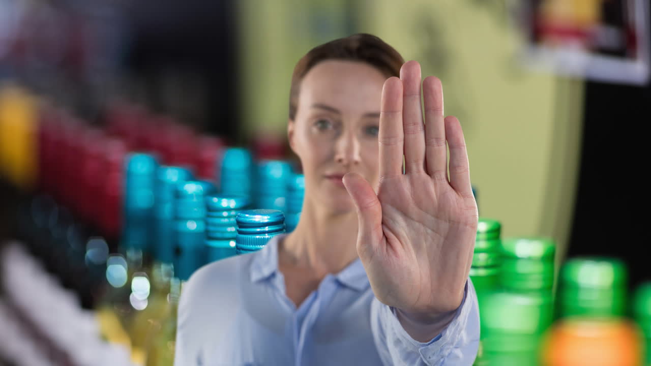animación de una mujer caucásica haciendo una señal de parada con la mano, sobre alcohol para la venta en la tienda