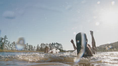 Fröhliche-Freunde,-Die-Bei-Sonnenuntergang-Im-See-Schwimmen-Und-Spaß-Daran-Haben,-Im-Wasser-Zu-Planschen,-Den-Sommer-Zu-Feiern-Und-Die-Freiheit-Zu-Genießen,-Indem-Sie-Am-Nachmittag-Gemeinsam-Schwimmen