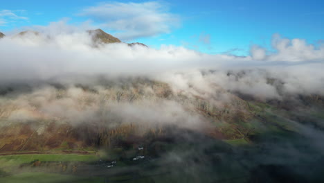 montaña envuelta por nubes con vuelo hacia a través de la niebla verde valle