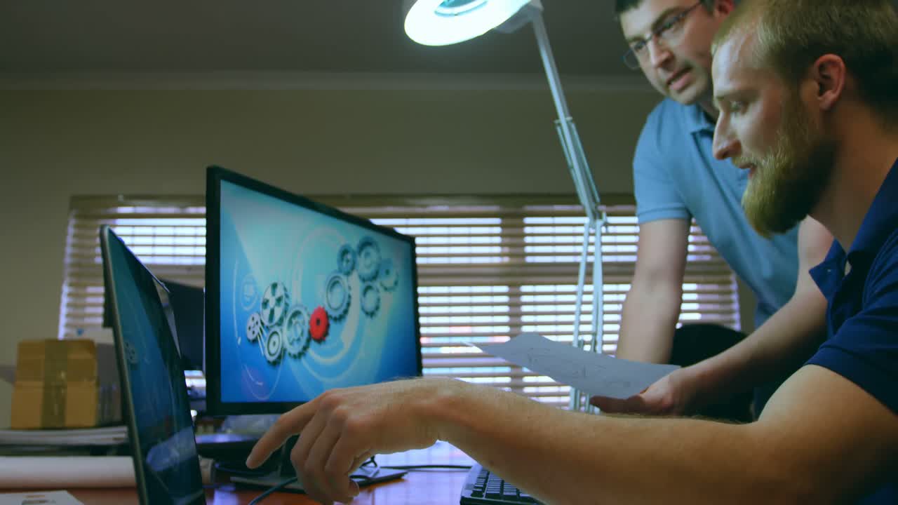 ingenieros robóticos masculinos discutiendo sobre la computadora portátil en el escritorio 4k