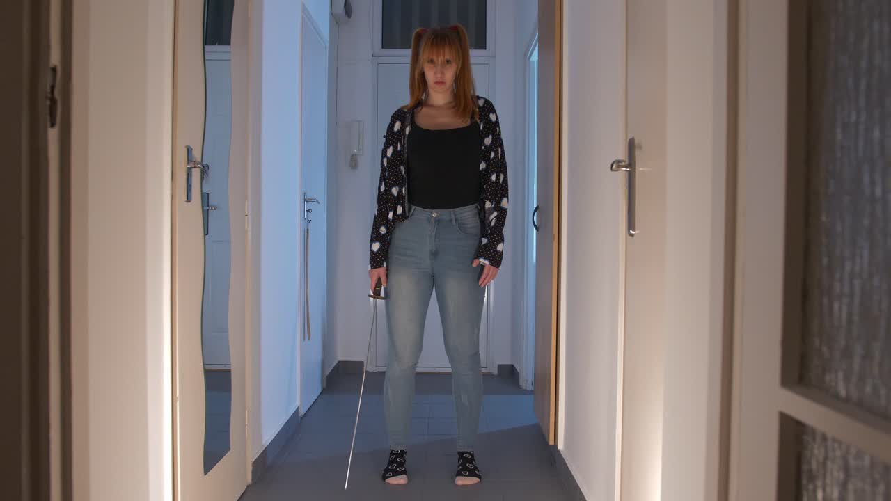 Sexy beautiful crewpy girl with a katana in the dark hallway