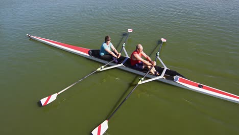 senior caucasian man and woman rowing boat on a river