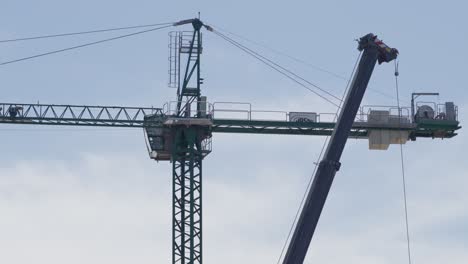 Crane-in-Full-Operation-Against-the-Backdrop-of-a-Clear-Blue-Day-Sky,-Illustrating-the-Dynamic-Harmony-Between-Construction-Power