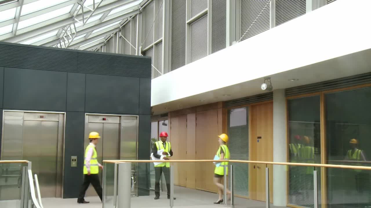 arquitectos con planes que hablan sobre la construcción de un edificio