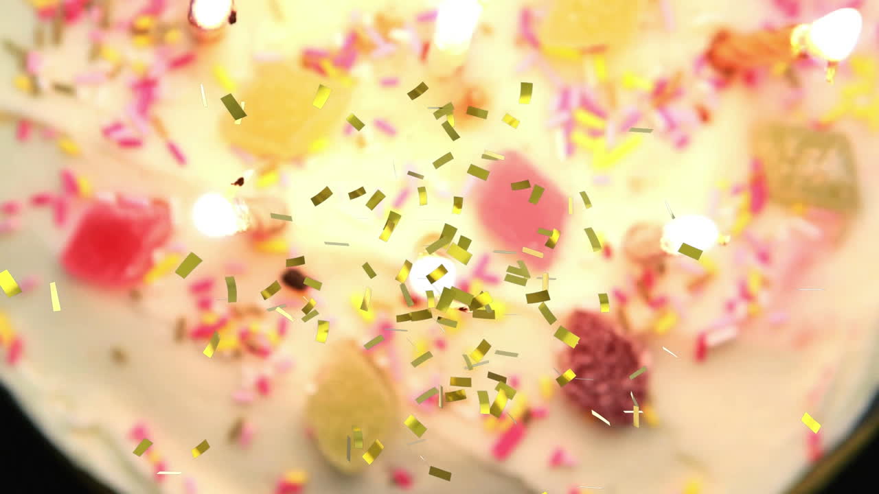 animación de confeti de oro cayendo sobre velas encendidas en el pastel de cumpleaños