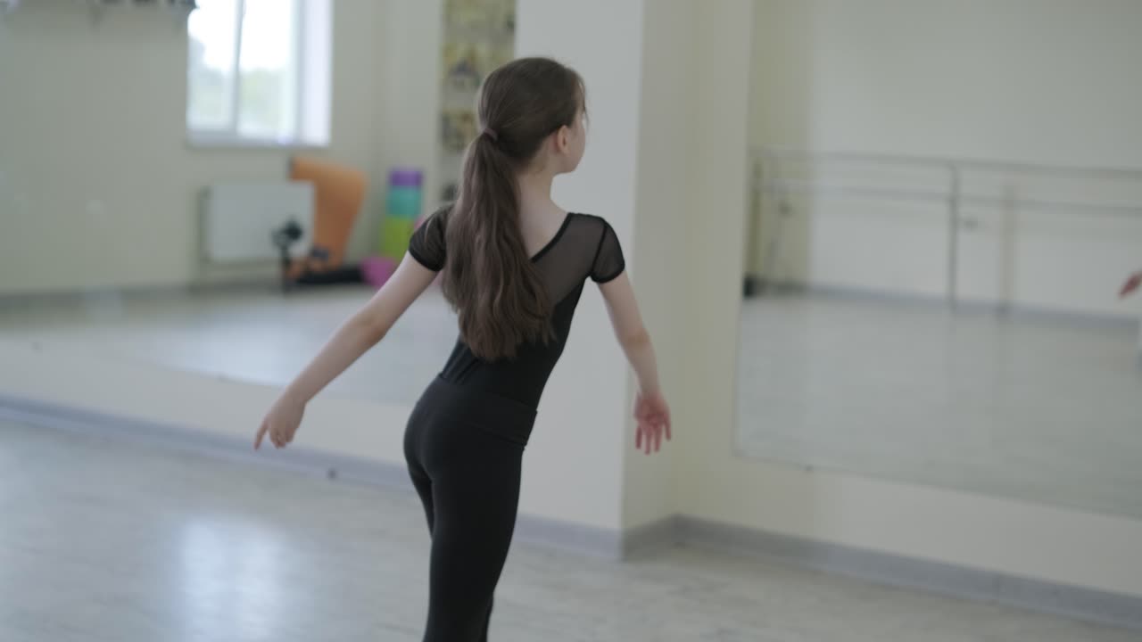 Giovane ballerina che pratica passi di danza in studio