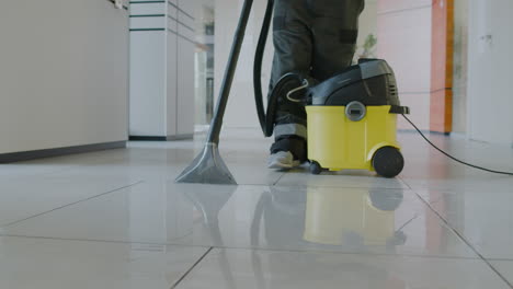 camera focuses a pressure water machine that is using a cleaning man inside an office building