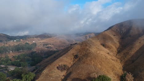 imágenes de drones de un helicóptero volando sobre montañas nubladas en los ángeles, california