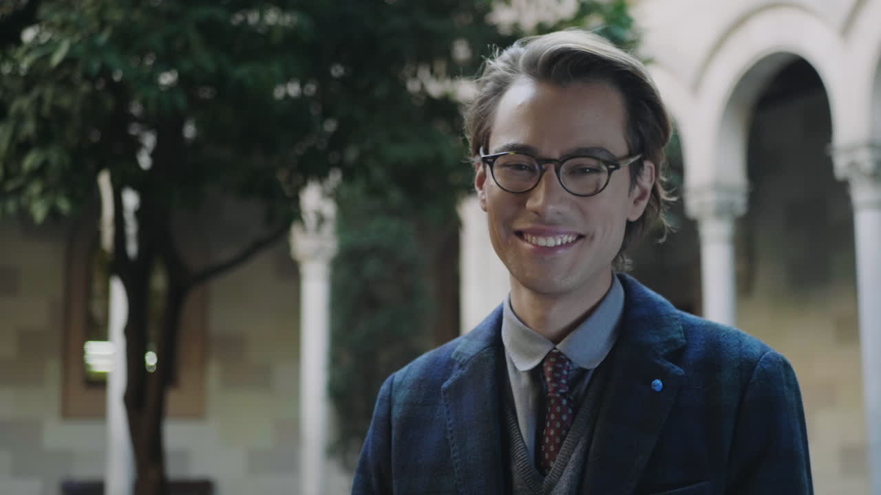 안경 을 입은 학생 이 카메라 를 보고 웃고 있다