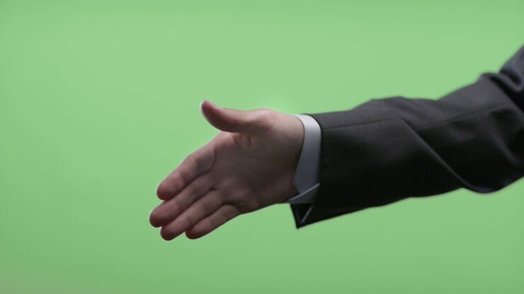 Businessman handshake on green screen.