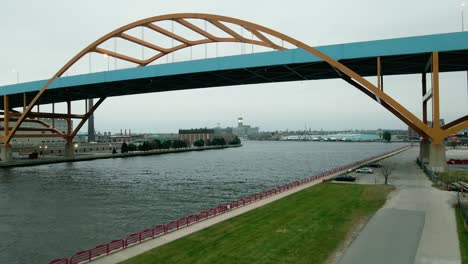 drone fly low under of arch bridge over milwaukee river near lake michigan