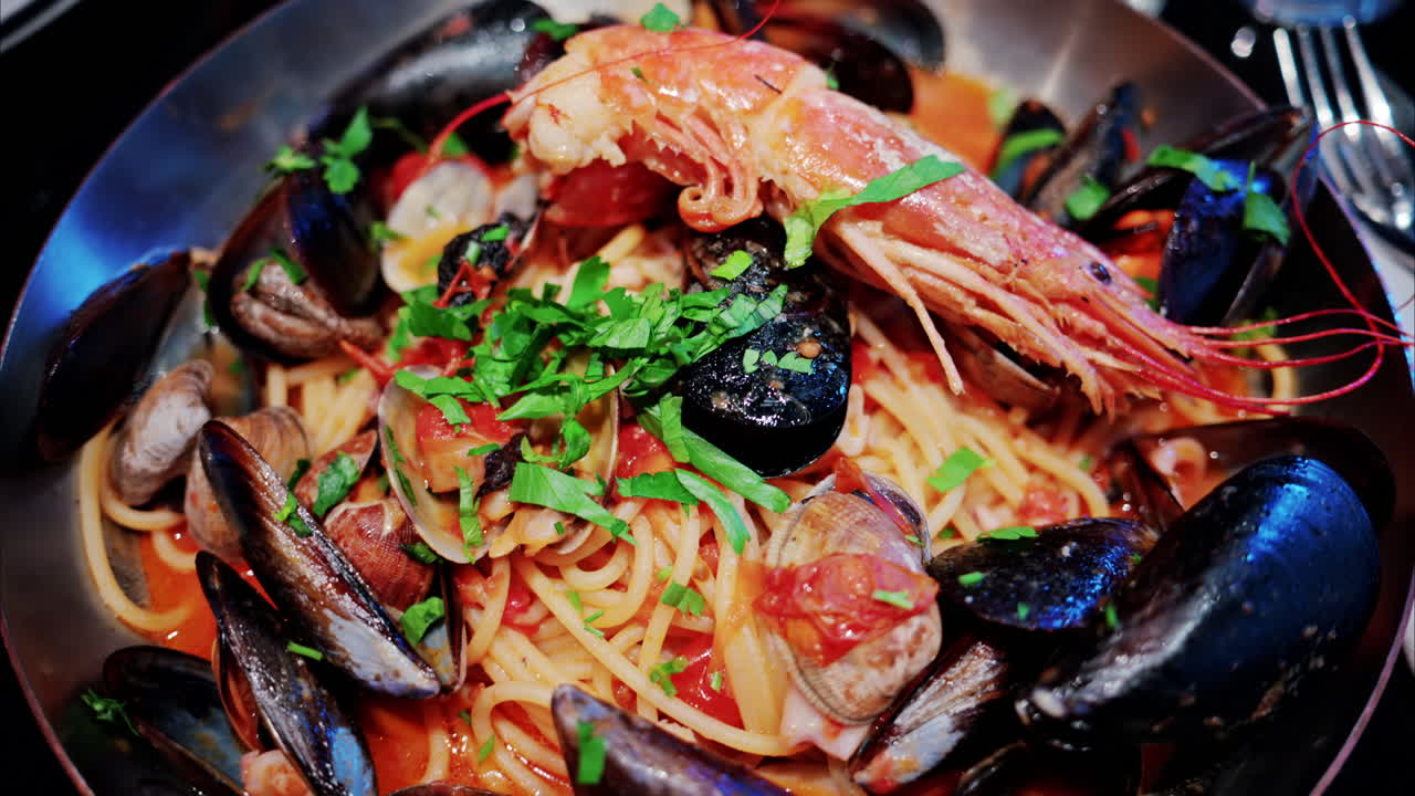 Close up of pasta with tomato sauce and mussels in a pan