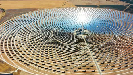 solar panels circular power plants with the reflection of the sunlight in the panels. renewable and pollution-free energy in a solar farm in spain- close-up view with a drone - environmental concept