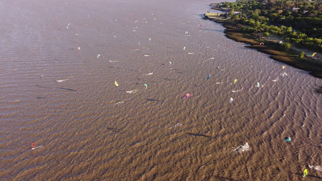 부에노스아이레스에서 화창한 날 강에서 서핑하는 카이트서퍼들의 군중을 보여주는 공중 하향식 샷