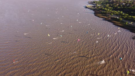 Toma-Aérea-De-Arriba-Hacia-Abajo-Que-Muestra-A-La-Multitud-De-Kitesurfistas-Surfeando-En-El-Río-Durante-El-Día-Soleado-En-Buenos-Aires