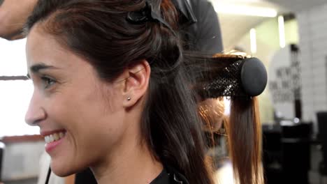 mujer secándose el cabello con un secador de pelo