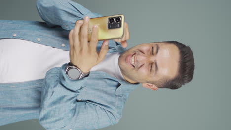 el video vertical del hombre mirando el teléfono es feliz.