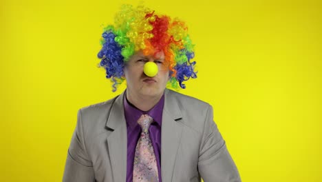 clown businessman entrepreneur boss in wig quarrels and waves his finger at work