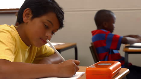 niño de escuela sonriendo a la cámara en clase