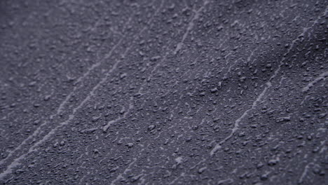 heavy rain running down on black waterproof textile