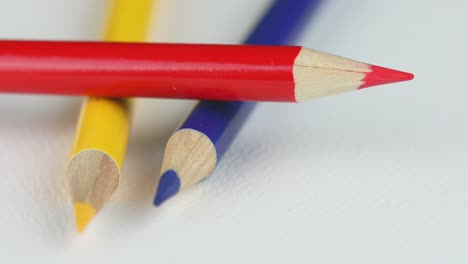 red, yellow, and blue colored pencils on white background - close up