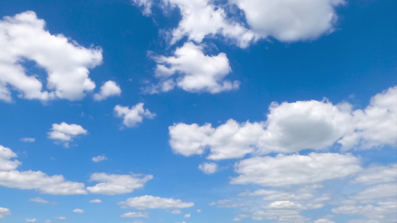 Constantly transforming white cotton clouds in the blue sky. Cumulus clouds building timelapse.