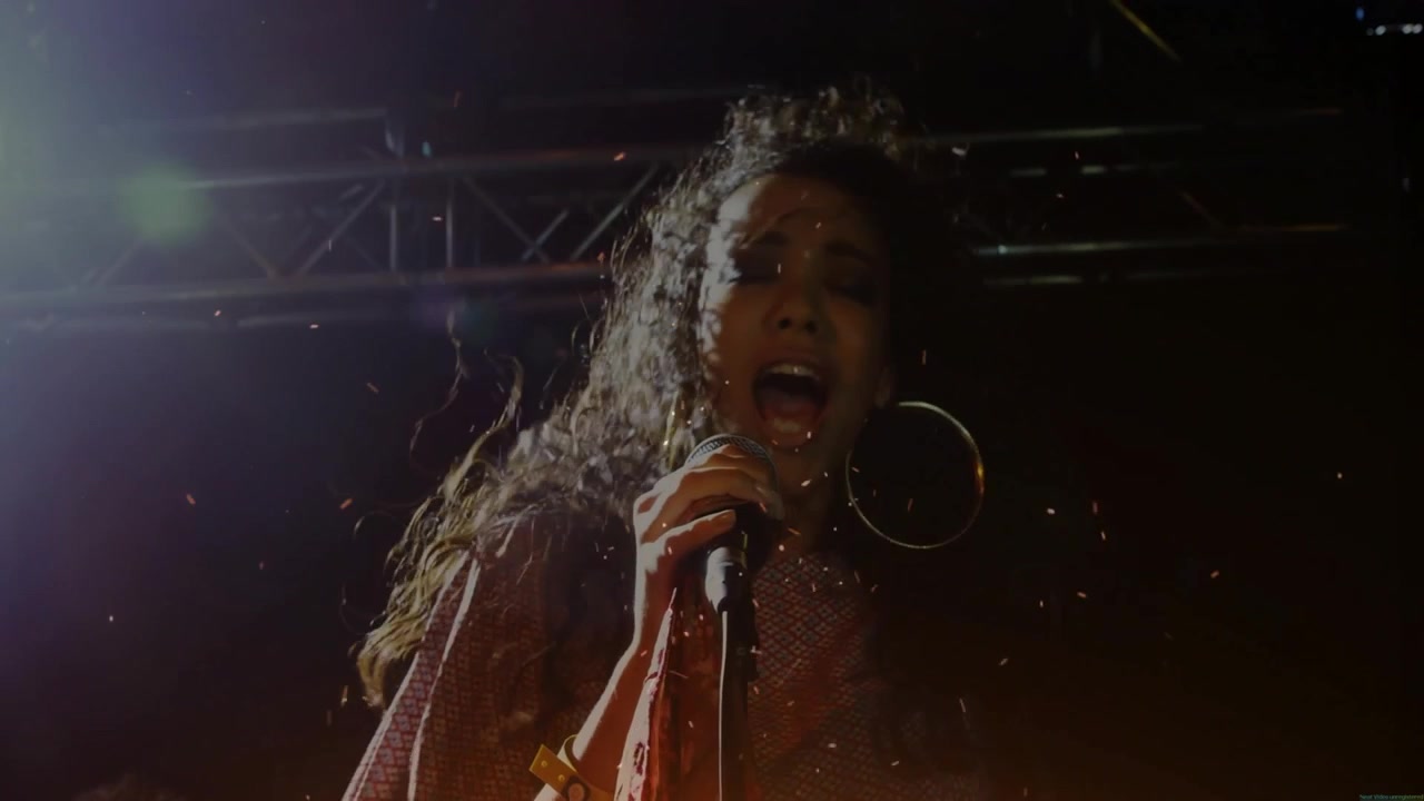 Female Singer Performing Energetically on Stage with Sparks