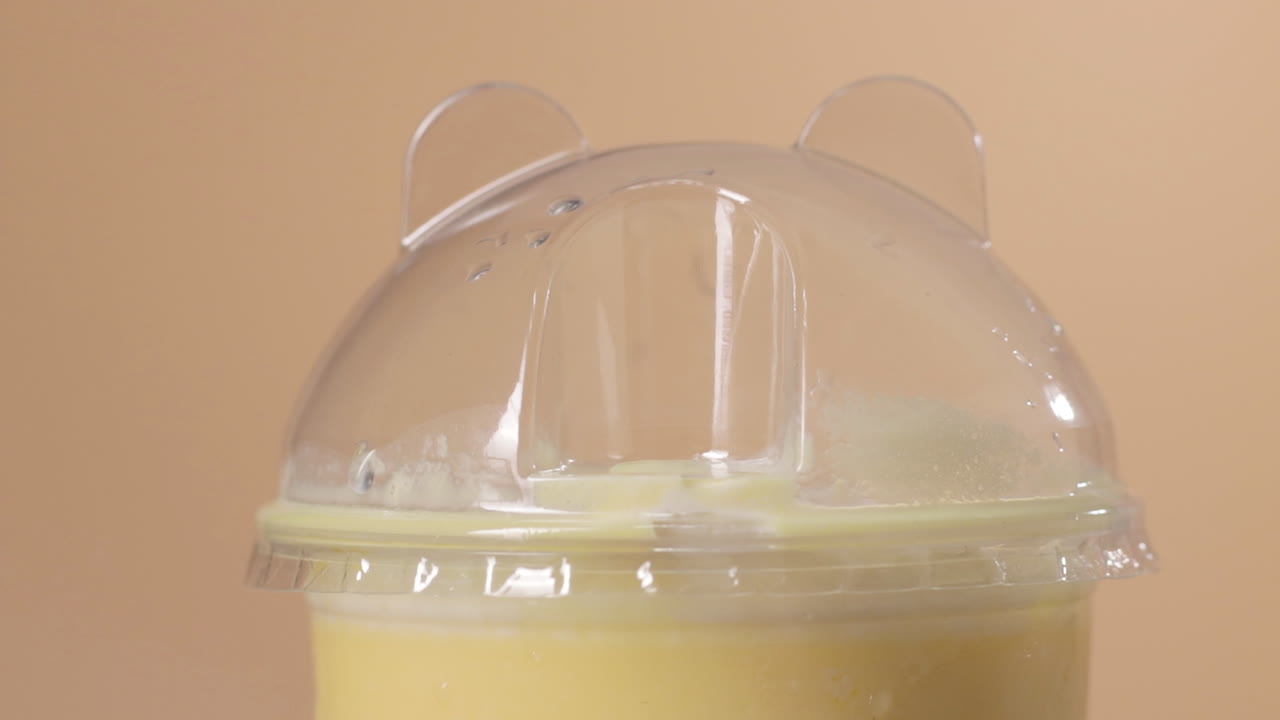 멋진 망고 밀크쉐이크 플라스틱 컵 위에 닫고 검은 빨대를 넣어주세요