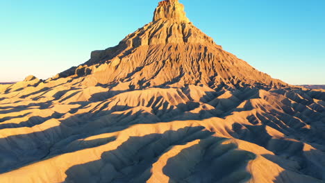 aerial view of factory butte in utah with a clear blue sky, reveal shot