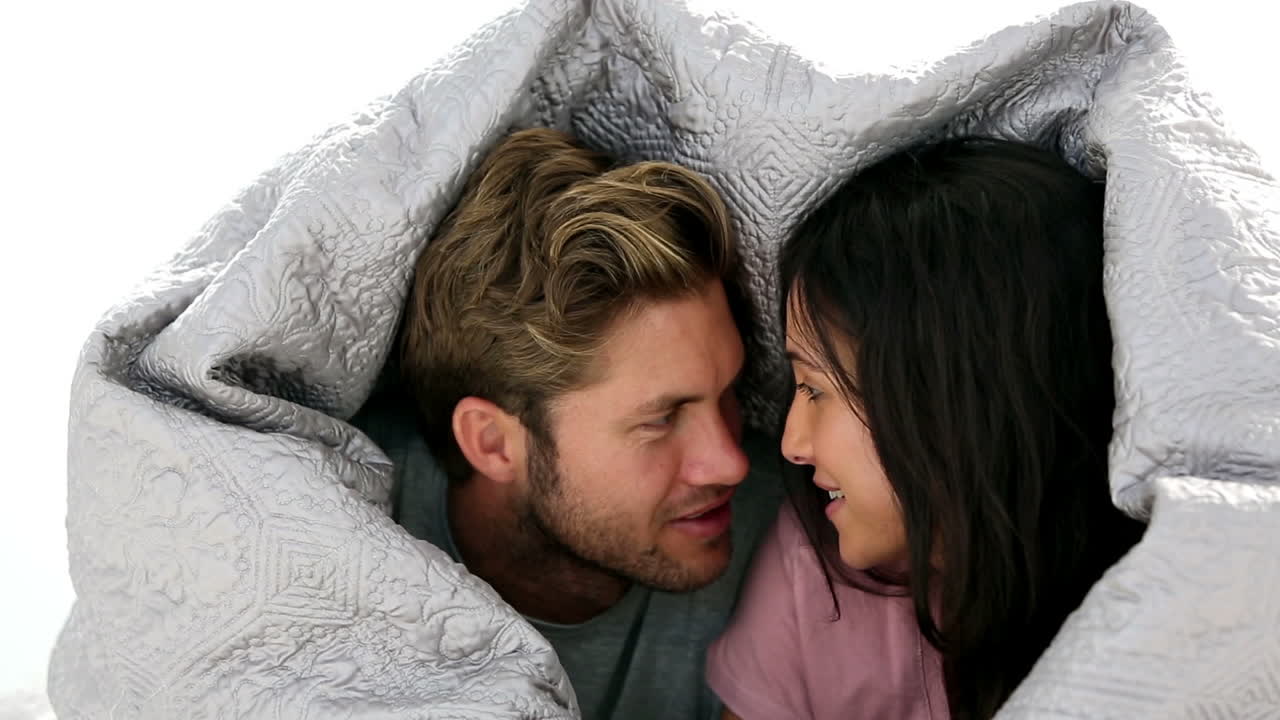 Couple chatting under the covers