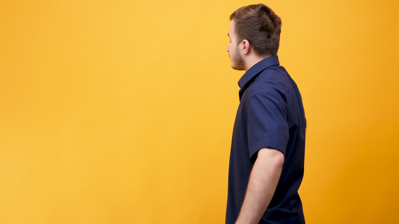 Uomo con una camicia blu su uno sfondo giallo
