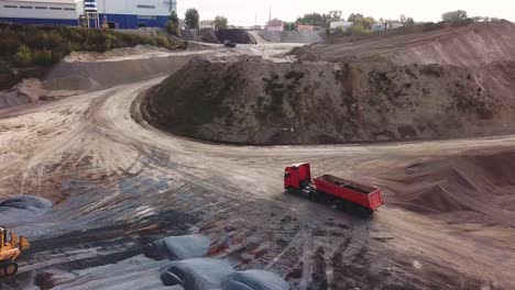 vista aérea de un pozo de grava con maquinaria pesada y un camión