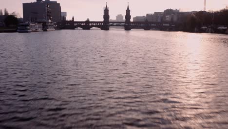 Cinematic-drone-flight-over-River-Spree-toward-Oberbaum-bridge,-Berlin,-Germany