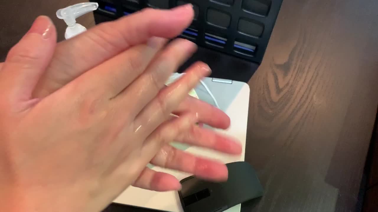 maestra frotando desinfectante de manos por todas sus manos para evitar que los gérmenes se propaguen