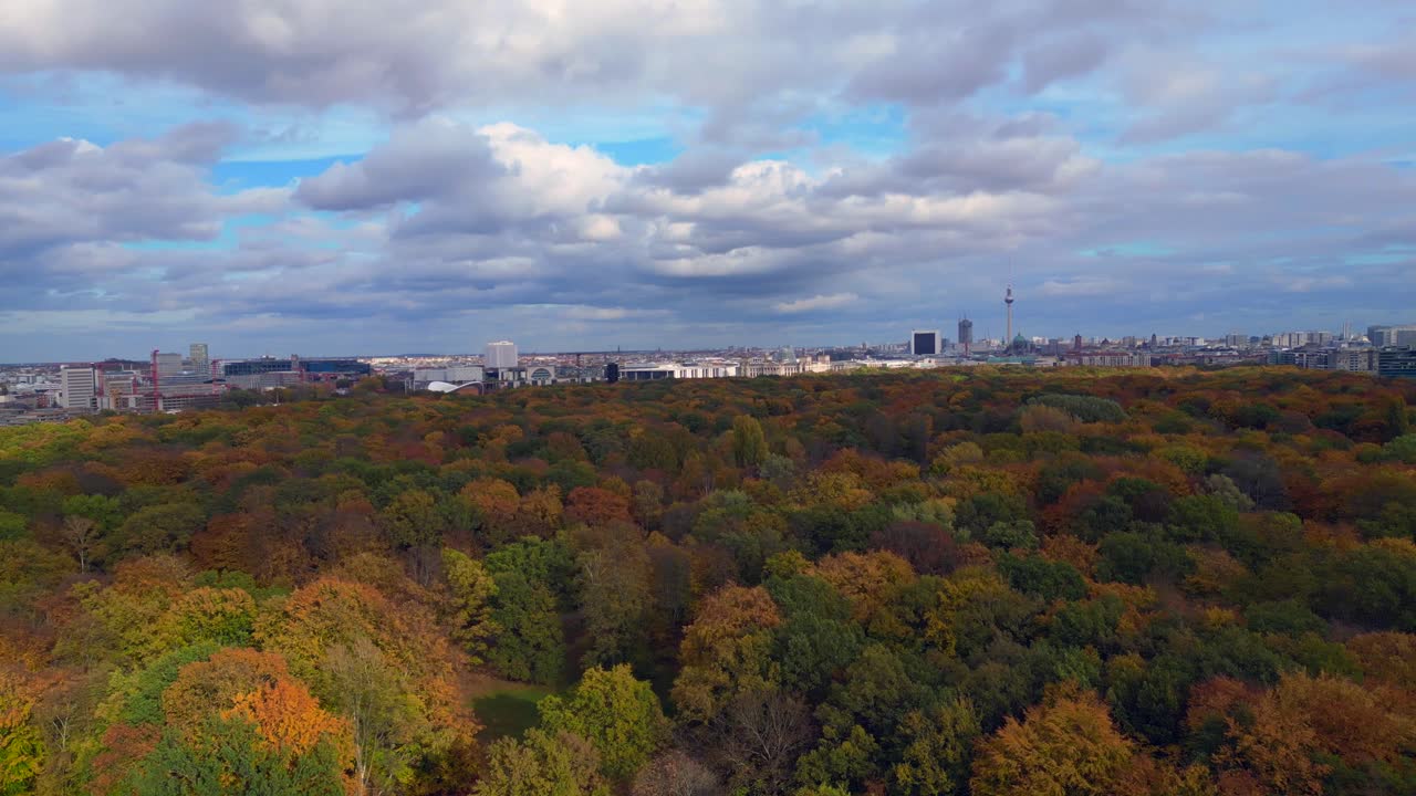 Berlin cityscape with fall colors of Tiergarten Park under cloudy sky. Gorgeous aerial view flight panorama overview rotation pan to right drone