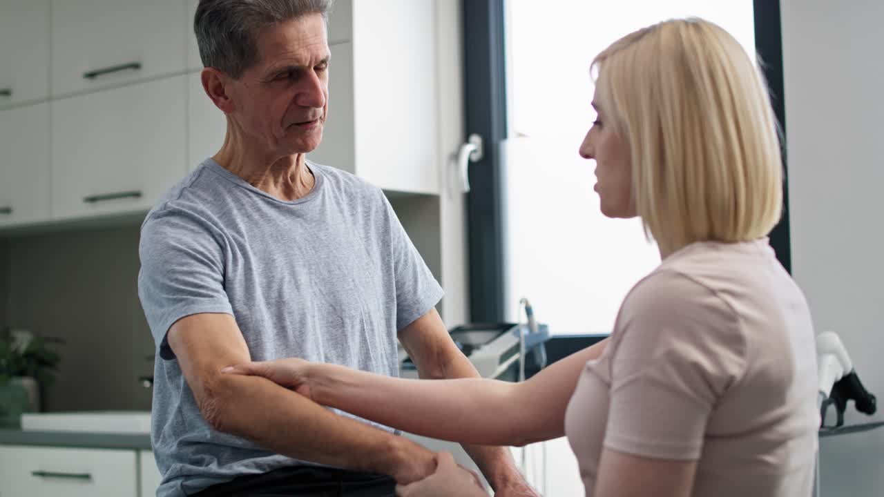 fisioterapeuta femenina trabajando con un hombre mayor.