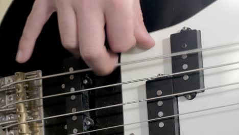 primer plano de la mano tocando un bajo eléctrico