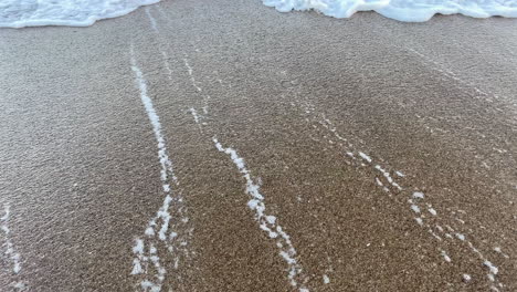 mediterranean sea water rushing onto the beach sand